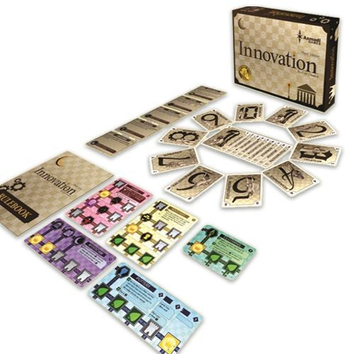 The game 'Innovation' by Asmadi Games is displayed with all its components. The box is shown at the back with a checkerboard design and the title 'Innovation.' Various game cards are laid out, including different colored cards and a rulebook. The cards feature gears and symbols, illustrating the game's mechanics and innovative gameplay.