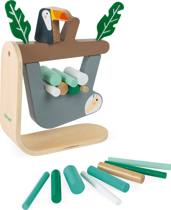 Sloth Balancing Game by Janod featuring a colorful wooden structure with a toucan on top and multiple cylindrical pieces in various colors placed nearby. The goal of the game is to balance the cylindrical pieces on the structure without toppling it.