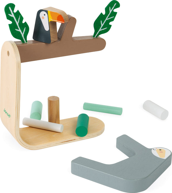 Sloth Balancing Game by Janod featuring a wooden base with a sloth and toucan on a tree branch. Includes various colored cylindrical blocks for balancing.