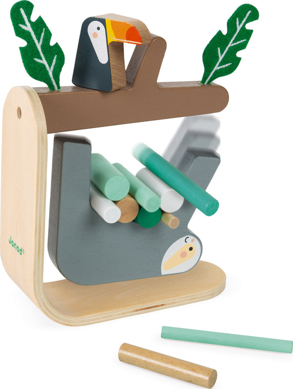 The Sloth Balancing Game by Janod features a wooden sloth structure with colorful sticks in various shades of green and beige. A toucan and leaves are perched atop the sloth, enhancing the vibrant jungle theme. The game encourages balance and dexterity as players stack rods without causing the sloth to topple.