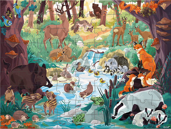 The Footprint Seek & Find Puzzle by Janod features a vibrant and colorful jigsaw scene depicting a forest filled with various animals including deer, foxes, and ducks near a flowing stream. The illustration includes rich greenery, mushrooms, and detailed animal characters, creating an engaging and educational experience for children as they search for different animal silhouettes within the puzzle.