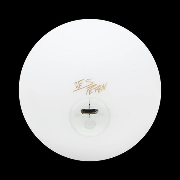 Top view of the Wes Peden LED juggling ball featuring a smooth, white exterior with a golden signature. The ball has a clear, illuminated center, designed for vibrant visual effects during juggling performances.