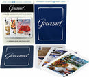 The Gourmet Poker Sized Playing Cards by New York Puzzle Company are beautifully designed with unique covers on each card. The deck showcases elegant imagery including floral arrangements, gourmet dishes, and intricate designs. The packaging is sophisticated, featuring a navy blue color with the word 'Gourmet' prominently displayed. Perfect for game nights or as a gift for card enthusiasts.