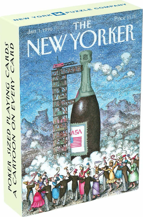 The 'Have A Drink Playing Cards' by New York Puzzle Company features a whimsical illustration with a large bottle and a rocket, surrounded by a festival-like scene with people in colorful costumes. The box showcases poker-sized playing cards with a cartoon on each card, perfect for entertaining gatherings and game nights.