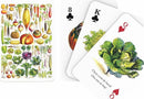 A set of Vegetable Playing Cards by New York Puzzle Company, featuring beautifully illustrated vegetable designs on the back of the cards and three face cards showing the 8 of spades, King of spades, and Queen of hearts, with detailed images of various vegetables including cabbage and squash.