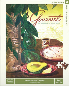A 500-piece jigsaw puzzle featuring the vibrant cover of 'Gourmet' magazine from April 1952. The artwork showcases fresh avocados, tortillas, and a decorative plate set against a background of lush green leaves and a carved figure, capturing a rich culinary aesthetic.