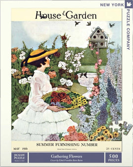 A vintage jigsaw puzzle featuring a woman in a white dress and yellow hat, gathering colorful flowers in a lush garden. The scene includes vibrant floral arrangements and a decorative birdhouse in a picturesque garden setting, inspired by a vintage magazine cover from May 1916.