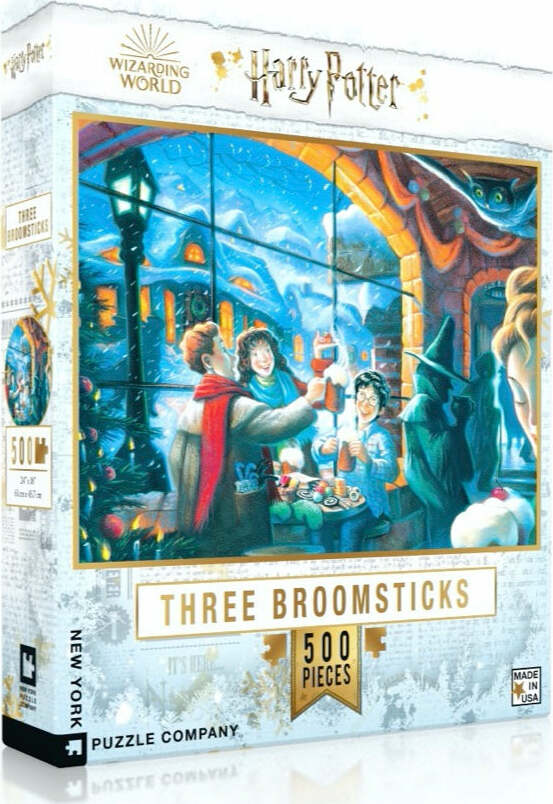 Harry Potter Three Broomsticks jigsaw puzzle by New York Puzzle Company, featuring a festive scene with characters enjoying drinks in a snowy setting. The box highlights the puzzle's 500 pieces and premium artwork depicting a charming interior with holiday decorations.