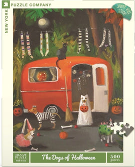 The Dogs of Halloween Puzzle featuring a whimsical scene with dogs dressed in Halloween costumes near an orange vintage caravan. The dogs include a dressed-up corgi and a striped dog, surrounded by spooky decorations like pumpkins, bones, and a black cat. Perfect for festive fun and family gatherings.