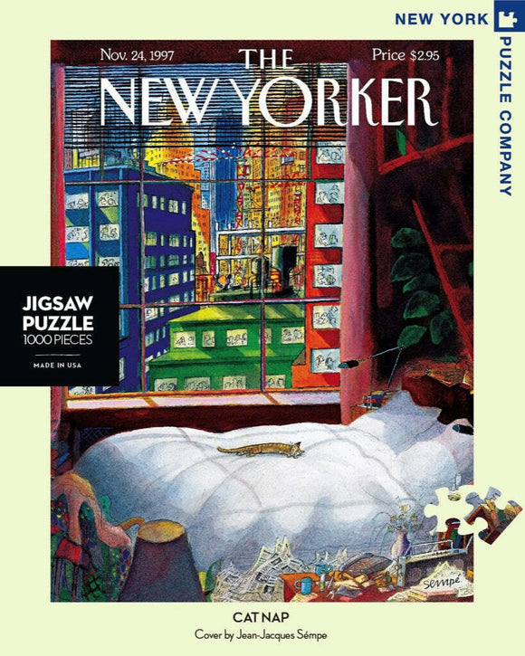 The 'Cat Nap Puzzle' features an illustration from The New Yorker, depicting a cozy bedroom scene with a cat sleeping on a bed, surrounded by art and colorful windows. This 1000-piece jigsaw puzzle captures the whimsical artwork of Jean-Jacques Sempé.
