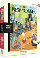 Off the Leash 1000-piece jigsaw puzzle by New York Puzzle Company. The puzzle features a humorous and colorful illustration of dogs and their owners enjoying a day at the park, engaged in various playful activities on a playground with a slide and swings. It captures a whimsical moment inspired by the artwork of Mark Ulrichsen.