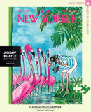 A vibrant jigsaw puzzle featuring a whimsical illustration of a person taking photographs of flamingos by a water body. The artwork showcases pink flamingos surrounded by lush greenery, capturing the playful essence of nature. Designed by Charles Saxon for The New Yorker, this 500-piece puzzle offers a delightful challenge and a beautiful scene once completed.