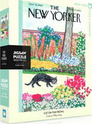 A colorful jigsaw puzzle box featuring the title "Cat on the Prowl" by New York Puzzle Company. The cover showcases a charming illustration of a cat wandering through a vibrant garden filled with flowers and greenery, reminiscent of a 1960s New Yorker magazine cover by William Steig. The puzzle includes 1000 pieces and is made in the USA.