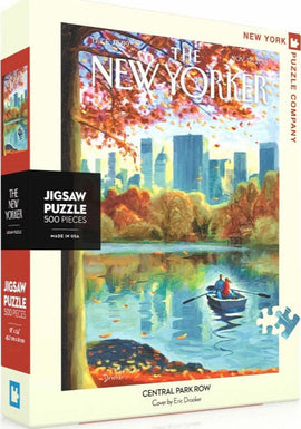 The Central Park Row Puzzle by New York Puzzle Company features a vibrant autumn scene inspired by Eric Drooker's artwork. The jigsaw puzzle contains 500 pieces and showcases a rowboat on a serene lake surrounded by colorful foliage and a city skyline in the background.
