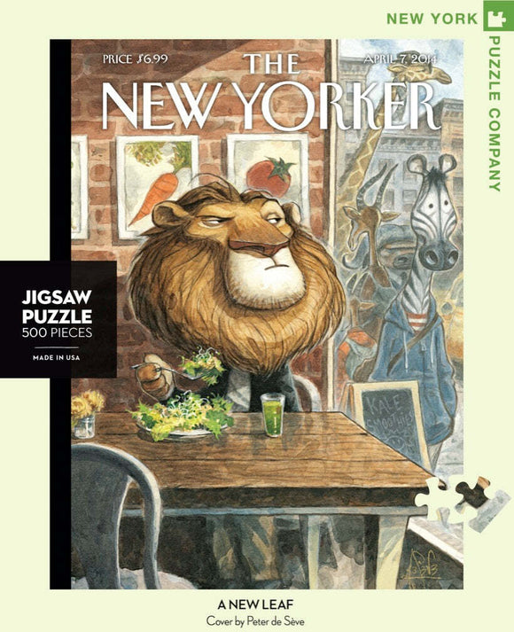 The New Leaf Puzzle features an illustrated scene inspired by a New Yorker cover, depicting a lion dining at a cafe table with a green drink, surrounded by whimsical animal characters in the background. This 500-piece jigsaw puzzle is a delightful challenge for enthusiasts.