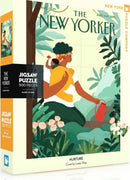 The Nurture Puzzle by New York Puzzle Company, featuring a vibrant box design inspired by a New Yorker cover. The illustration depicts a woman with curly hair holding a watering can amidst lush greenery and blooming flowers, emphasizing nurturing and nature. Contains 500 pieces and is made in the USA.