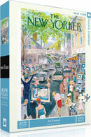 Art Festival Jigsaw Puzzle (1000pc) by New York Puzzle Company. The puzzle features a colorful illustration depicting a bustling outdoor art festival from a 1959 New Yorker magazine cover, complete with art vendors and lively crowds.