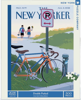 A colorful jigsaw puzzle featuring an illustration from The New Yorker magazine. The scene depicts two bicycles parked beside a "No Parking" sign, while a couple walks along a path, enjoying a sunny day. The puzzle has 500 pieces and is titled 'Double Parked', created by artist R. Kikuo Johnson.
