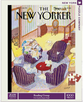 A colorful jigsaw puzzle titled 'Reading Group' by New York Puzzle Company, featuring an illustration of a cozy living room with several people reading together. The scene includes plush purple armchairs, a circular rug, and a round coffee table with scattered reading materials. The puzzle comprises 1000 pieces and includes the cover art by Jean-Jacques Sempé from the New Yorker.