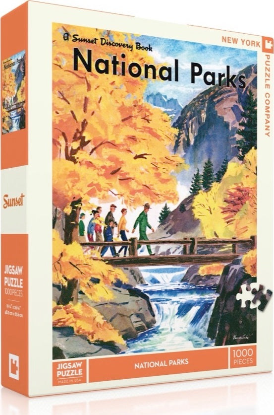 New York Puzzle Company's National Parks Jigsaw Puzzle featuring vibrant autumn scenery with a group of hikers on a bridge over a stream. The puzzle includes 1000 pieces and showcases a picturesque landscape with colorful foliage and mountains in the background.