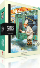 The Just a Pinch jigsaw puzzle from New York Puzzle Company features a whimsical illustration by Peter de Séve, depicting a chef in a snowy street scene with vibrant colors and engaging details. The puzzle contains 1000 pieces and comes in a stylish box showcasing the artwork on the front.