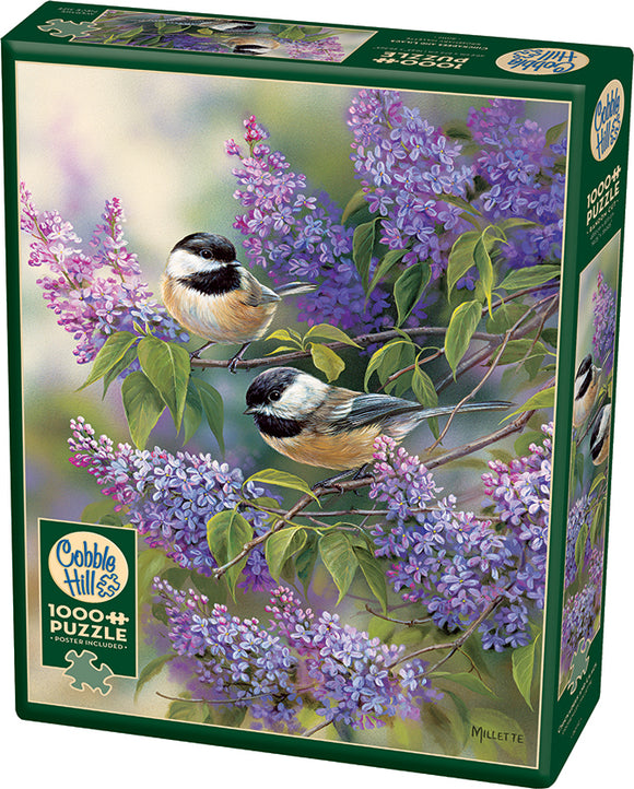 A jigsaw puzzle box featuring the artwork 'Chickadees and Lilacs' by Cobble Hill. The image depicts two chickadee birds perched on a lilac branch surrounded by vibrant purple flowers and lush green leaves. The vibrant artwork illustrates the beauty of nature, making it an inviting puzzle design. The box is prominently labeled with the Cobble Hill logo and the puzzle's piece count, showcasing a high-quality relaxing activity for enthusiasts of all ages.