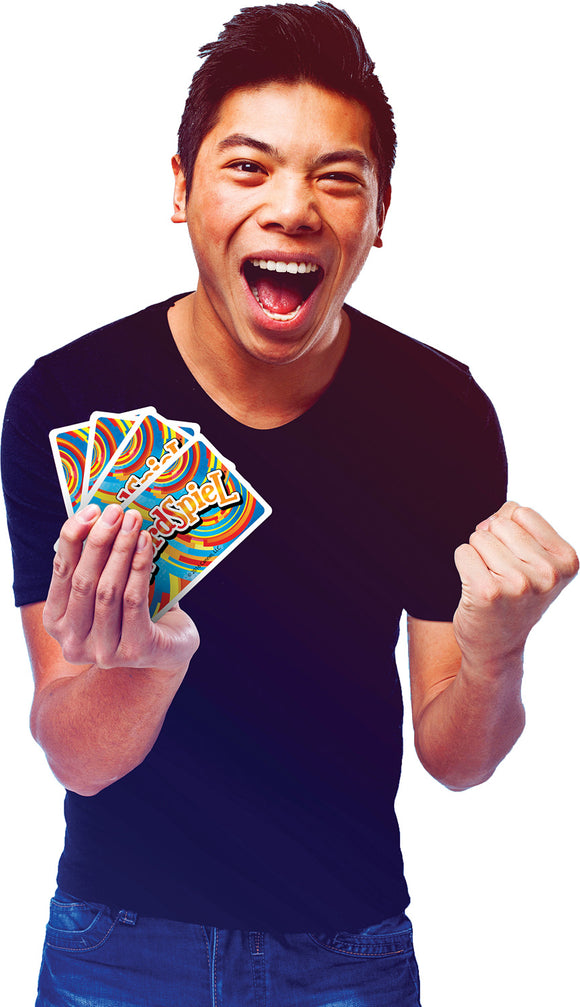 A young man enthusiastically holds up a set of colorful cards from the game WordSpiel. He is wearing a black shirt and has an animated, joyful expression on his face, with his mouth open in a smile and his fist raised in excitement.