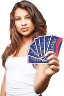 A young woman holds a hand of Quiddler cards, showcasing their blue back design with gold lettering. The focus is on her confident expression and the colorful cards in her hand, highlighting the fun of this engaging word game.