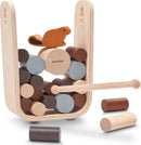 Timber Tumble by Plan Toys is a wooden stacking game featuring a cute beaver character atop a collection of colorful wooden cylinders. The game helps develop fine motor skills and balance as players stack the cylinders while trying to keep the beaver balanced. The set includes a striking tool and is designed for interactive play, promoting creativity and cognitive skills.