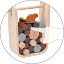 The Timber Tumble game by Plan Toys features a wooden carrying case filled with colorful cylindrical pieces. A playful beaver figure sits atop the pile, inviting children to engage in imaginative play and skill-building activities.