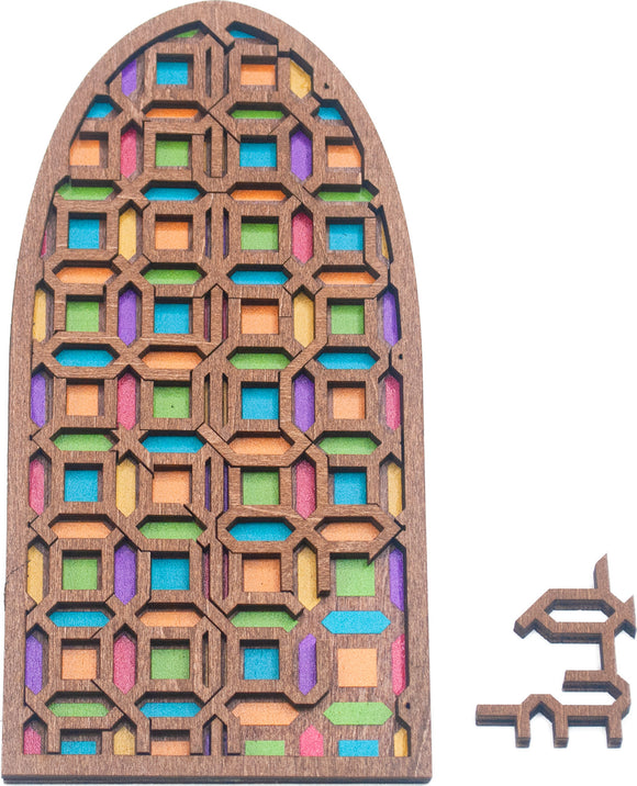 A beautifully crafted mechanical puzzle in the shape of a stained glass cathedral door. The puzzle features a wooden frame with colorful geometric patterns cut out, showcasing vibrant pieces in orange, purple, green, blue, and pink. One additional piece is placed beside the main puzzle, adding to the challenge and design.