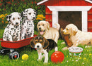 A colorful jigsaw puzzle titled 'Puppy Party' featuring five playful puppies in a sunny garden. Two Dalmatian puppies sit in a red wagon, surrounded by a yellow ball, a red ball, and a dog bowl with bones. A golden Labrador puppy smiles next to an old boot, while a Beagle puppy occupies the foreground. The backdrop includes vibrant flowers and a red dog house.