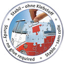 A close-up image of a Ravensburger jigsaw puzzle featuring a VW Bus T1. The image shows a hand inserting a puzzle piece into the bus structure. The circular border reads 'Stabil – ohne Klebstoff' in German and 'Sturdy – no glue required' in English, highlighting the ease of assembly. Colorful pieces with numbers are partially fitted together, demonstrating the vibrant design of the puzzle.