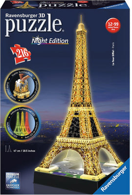 A Ravensburger 3D puzzle depicting the Eiffel Tower in its Night Edition. The puzzle includes 216 pieces and features a vibrant, illuminated design. The packaging shows the completed puzzle, showcasing how the iconic Parisian landmark lights up, with a height of 47 cm (18.5 inches). Instructions for assembly and details about the color LED lights included are also visible.