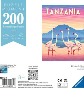 Ravensburger Tanzanian jigsaw puzzle featuring five flamingos in a serene landscape with a mountain backdrop. The puzzle has 200 pieces and is designed for ages 8 and up, emphasizing relaxation and enjoyment.