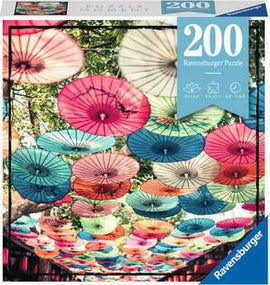 Puzzle Moments: Umbrellas 200 by Ravensburger, featuring a vibrant jigsaw puzzle design with colorful umbrellas hanging overhead against a tree background. Perfect for puzzle enthusiasts looking for a fun and colorful challenge.