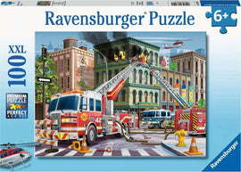 Ravensburger Fire Truck Rescue jigsaw puzzle box featuring an exciting fire scene with multiple fire trucks, firefighters, and a burning building. The illustration showcases detailed action with ladders reaching the windows and a helicopter flying overhead, suitable for ages 6 and up.