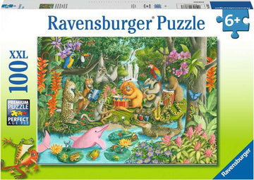 A colorful jigsaw puzzle box featuring the Rainforest River Band, made by Ravensburger. The image depicts a vibrant jungle scene with various animals including a bear, monkey, parrot, and more, playing musical instruments by the river. The puzzle contains 100 pieces and is suitable for ages 6 and above, emphasizing its premium quality and age fit.