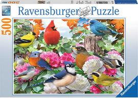 A vibrant jigsaw puzzle by Ravensburger featuring a stunning array of garden birds such as a cardinal, blue jay, goldfinch, and various other species amidst colorful flowers and lush green leaves. The puzzle contains 500 pieces, designed for both challenge and enjoyment, showcasing the beauty of nature.