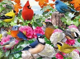 A vibrant jigsaw puzzle featuring a variety of colorful garden birds perched among lush greenery and blooming flowers. The scene includes finches, a robin, and a cardinal, creating a lively and cheerful ambiance.