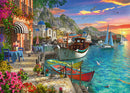 A vibrant jigsaw puzzle titled 'Grandiose Greece' by Ravensburger showcasing a picturesque Greek harbor. The scene features colorful boats docked along a stone pathway adorned with blooming flowers and tables under a striped awning. In the background, quaint buildings with blue domes and mountains reflect in the shimmering turquoise water, under a spectacular sunset sky.