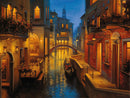 A serene canal scene in Venice illuminated by warm, enchanting lights at dusk. The image features classic Venetian architecture, a quaint bridge, and a gondola gliding smoothly along the shimmering water, creating a tranquil ambiance for a jigsaw puzzle titled 'Waters of Venice' by Ravensburger.