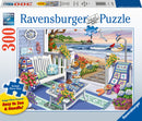 Ravensburger jigsaw puzzle titled 'Seaside Sunshine,' featuring a cozy coastal patio scene complete with a swing bench, vibrant flowers, decorated tables with treats, and a scenic beach view in the background. The puzzle has 300 large pieces designed for easy handling and visibility.