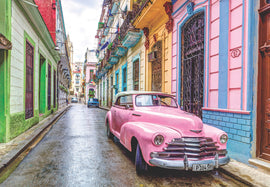 Ravensburger jigsaw puzzle titled 'Cuba', featuring a vibrant street scene showcasing colorful buildings and a classic pink convertible parked in a narrow alley, capturing the essence of Havana's charm.