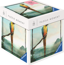 A Ravensburger jigsaw puzzle titled 'Parrot' featuring a colorful parrot perched on a branch against a scenic landscape backdrop. The puzzle box displays 99 pieces and is part of the 'Puzzle Moment' series, showcasing intricate details and vibrant colors.