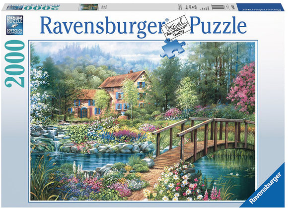 Ravensburger jigsaw puzzle titled 'Shades of Summer', featuring a scenic landscape with a colorful garden, a winding river, and a charming wooden bridge leading to a cozy house surrounded by lush greenery.