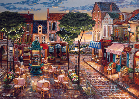 A beautifully illustrated jigsaw puzzle depicting a charming cafe scene in an evening setting. The image features quaint buildings with intricate details, outdoor seating with round tables draped in pink tablecloths, vibrant flower arrangements, and a glimmering light post. There's a fountain in the background and the silhouette of the Eiffel Tower peeking over the rooftops, creating a romantic ambiance. Perfect for puzzle enthusiasts who appreciate art and café culture.