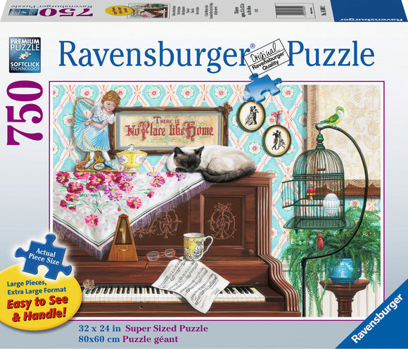 A colorful jigsaw puzzle box featuring a cozy scene with a cat lounging on a wooden piano. The scene includes a girl holding a bowl, a sign that reads 'There's No Place Like Home,' sheet music, a cup, and decorative items like a birdcage and flowers. The dimensions of the completed puzzle are 32 x 24 inches.