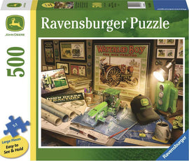 John Deere Work Desk jigsaw puzzle featuring a detailed workspace with vintage tractor memorabilia, green tractor model, blueprints, and stationery. The puzzle includes 500 large pieces that are easy to see and hold, making it a perfect choice for puzzle enthusiasts and fans of farming history.