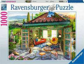 Ravensburger jigsaw puzzle titled 'Tuscan Oasis' featuring a vibrant scene of a cozy room with colorful furniture and picturesque views of a Tuscan landscape, complete with a stone pathway and lush greenery. The puzzle consists of 1000 pieces and showcases intricate details and softclick technology for easy assembly.